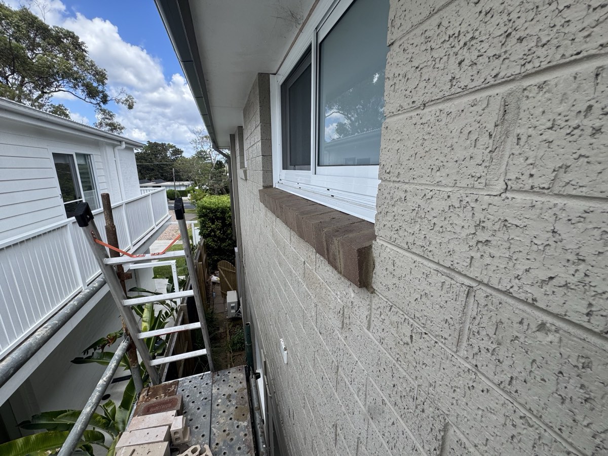 Exterior wall repair and painting from a ladder